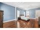 Main bedroom with hardwood floors, light blue walls, and a large bed at 3998 St Georges Ct, Duluth, GA 30096