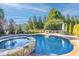 Inviting kidney-shaped pool with a spa, surrounded by landscaping and patio furniture at 3998 St Georges Ct, Duluth, GA 30096