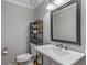 Modern powder room with a floating vanity, stylish mirror, and wood-look flooring at 820 Oak Ter, Norcross, GA 30071