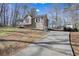 Tan house with white shutters, a wooden deck, and a long driveway at 15 Indian Woods Ne Dr, Rydal, GA 30171