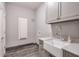 Modern laundry room with farmhouse sink and gray cabinets at 2465 Henderson Rd, Tucker, GA 30084