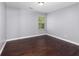 Simple bedroom with hardwood floors and a window at 1598 Blue Spruce Ln, Conyers, GA 30012