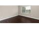Spacious bedroom with dark hardwood floors and large window at 1598 Blue Spruce Ln, Conyers, GA 30012