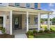 Covered front porch with brick columns and a bench at 165 Poppy St, Mcdonough, GA 30253