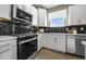 Modern kitchen with stainless steel appliances and dark tile backsplash at 165 Poppy St, Mcdonough, GA 30253