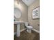 Modern powder room with pedestal sink, toilet, and wood-look flooring at 165 Poppy St, Mcdonough, GA 30253