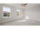 Bright bedroom with carpet flooring, ceiling fan, and two large windows at 305 Foxglove Way, Mcdonough, GA 30253