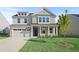 Two-story brick home with a large front yard and attached garage at 305 Foxglove Way, Mcdonough, GA 30253