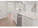 Modern kitchen with white cabinets, stainless steel dishwasher, and quartz countertops at 305 Foxglove Way, Mcdonough, GA 30253