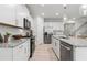Contemporary kitchen with stainless steel appliances, granite counters, and a seamless flow to the adjacent staircase at 316 Foxglove Way, Mcdonough, GA 30253