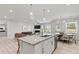 Open-concept layout featuring a kitchen island, granite countertops, and a view to the dining area and living room at 316 Foxglove Way, Mcdonough, GA 30253