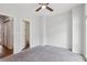 Bedroom with ceiling fan and grey carpeting, open to bathroom at 457 Parkway Ne Dr, Atlanta, GA 30308