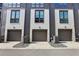 Three-unit townhome building with modern gray and white exterior, attached garages, and landscaping at 457 Parkway Ne Dr, Atlanta, GA 30308