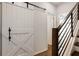 A hallway with a white barn door and a modern wooden staircase at 457 Parkway Ne Dr, Atlanta, GA 30308