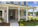 Covered front porch with white columns, a blue door, and a bench at 344 Foxglove Way, Mcdonough, GA 30253