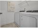 Bright laundry room with washer, dryer, and overhead shelving at 344 Foxglove Way, Mcdonough, GA 30253