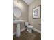 Stylish powder room with pedestal sink, wood-look floors, and framed art at 344 Foxglove Way, Mcdonough, GA 30253