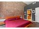 Main bedroom with exposed brick, displaying artwork, and leading to an ensuite bathroom at 350 Peters Sw St # 3, Atlanta, GA 30313