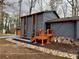 Side exterior view of a home with a wood deck, stone accents, and freshly painted blue siding at 296 Grist Mill Ln, Lawrenceville, GA 30046