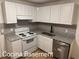 A kitchen with white cabinets, gray countertops, and stainless steel appliances at 296 Grist Mill Ln, Lawrenceville, GA 30046