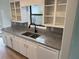 Bright kitchen featuring white cabinets, granite countertops, stainless steel sink and faucet, and wooden floors at 296 Grist Mill Ln, Lawrenceville, GA 30046