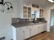 Bright kitchen featuring white cabinets, granite countertops, stainless steel sink and faucet, and wooden floors at 296 Grist Mill Ln, Lawrenceville, GA 30046