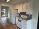 Full view of kitchen featuring white appliances, granite countertops, stainless steel sink and faucet, and wooden floors at 296 Grist Mill Ln, Lawrenceville, GA 30046
