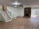 Open living room showcasing wood flooring, fireplace, ceiling fan and staircase at 296 Grist Mill Ln, Lawrenceville, GA 30046
