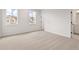 Light-filled bedroom features neutral carpet, windows, and a door to bathroom at 715 Crossroad Ct, Powder Springs, GA 30127