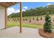 Covered patio overlooking a landscaped backyard with a line of small trees, offering a serene outdoor space at 715 Crossroad Ct, Powder Springs, GA 30127
