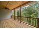 Enjoy the outdoors from this back porch with wooden floors and ceiling fan overlooking lush trees at 220 Autumn Brook Dr, Canton, GA 30115