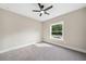 A bright bedroom featuring neutral walls, plush gray carpet, and a modern ceiling fan with a window at 220 Autumn Brook Dr, Canton, GA 30115
