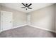A cozy bedroom featuring neutral walls, plush gray carpet, and a modern ceiling fan with integrated lighting at 220 Autumn Brook Dr, Canton, GA 30115