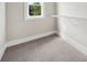 Walk-in closet featuring neutral walls, plush gray carpet, a small window, and a metal storage shelf at 220 Autumn Brook Dr, Canton, GA 30115