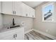 Laundry room featuring white cabinets, granite counters, and modern fixtures at 220 Autumn Brook Dr, Canton, GA 30115