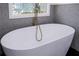 Free standing bathtub with gold fixtures and penny tile surround at 1043 Smith Sw St, Atlanta, GA 30310