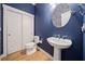 Powder room with pedestal sink, white toilet, and navy blue walls at 228 Dawson Dr, Woodstock, GA 30188