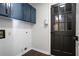 Bright laundry room with blue cabinets, white subway tile, and dark door at 3581 Baywater Trl, Snellville, GA 30039
