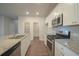 Open kitchen featuring granite countertops and stainless steel appliances at 337 Amsterdam Way, Hampton, GA 30228