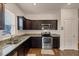 Modern kitchen with dark cabinets, stainless steel appliances, and granite counters at 7250 Lacey Dr, Douglasville, GA 30134