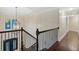 Hallway with an ornate iron banister, dark hardwood floors, and chandelier lighting at 2725 Castel Ln, Cumming, GA 30040