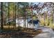Home exterior with a long driveway, surrounded by mature trees, providing a sense of privacy at 5823 Button Gwinnett Pl, Norcross, GA 30093