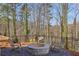 Cozy backyard firepit area with seating, perfect for outdoor entertaining, and relaxation under the trees at 165 Grayton Ln, Roswell, GA 30075