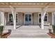 Covered front porch with stone flooring, blue double doors, and decorative seating at 165 Grayton Ln, Roswell, GA 30075