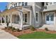 Inviting front porch featuring gray siding, white columns, blue front door, and decorative landscaping at 165 Grayton Ln, Roswell, GA 30075