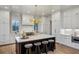 Modern kitchen featuring white cabinets, marble countertops, an island with seating, and decorative lighting at 165 Grayton Ln, Roswell, GA 30075