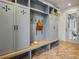 Well-organized mudroom with built-in storage, seating, and stylish herringbone tile flooring at 165 Grayton Ln, Roswell, GA 30075