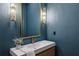 Stylish powder room with a modern vanity, vessel sink, unique lighting fixtures, and elegant blue walls at 165 Grayton Ln, Roswell, GA 30075