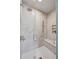 Luxurious shower showcasing marble-like tile, a glass door, dual showerheads, and a convenient built-in seating area and shelf at 165 Grayton Ln, Roswell, GA 30075