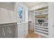 Well-organized walk-in closet with shelves, drawers, hanging rods and a window providing natural light at 165 Grayton Ln, Roswell, GA 30075